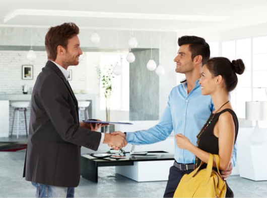 letting agent shaking hands with couple